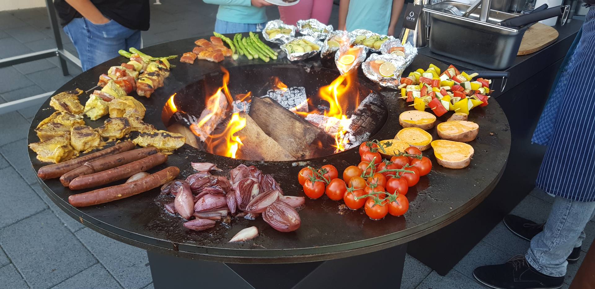 Feuerschale mit runder Grillplatte Außenrum und Grillgemüse