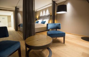 Sitzecke mit Blick aufs Doppelbett in modernen Hotelzimmer