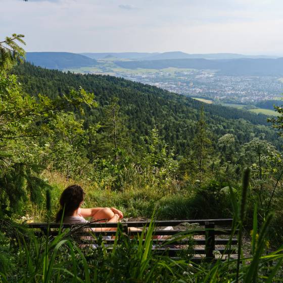 Frau auf Bank genießt Ausblick vom Berg auf die Region Tuttlingen 