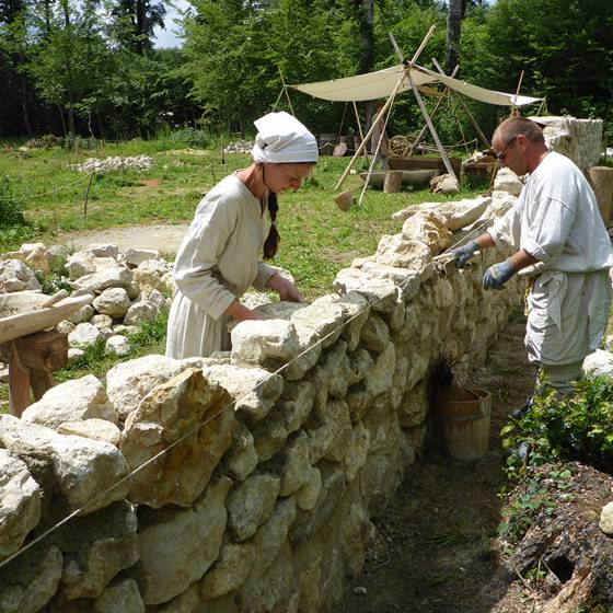 Personen auf dem Obstgartenbauer-Campus bauen Steinmauer