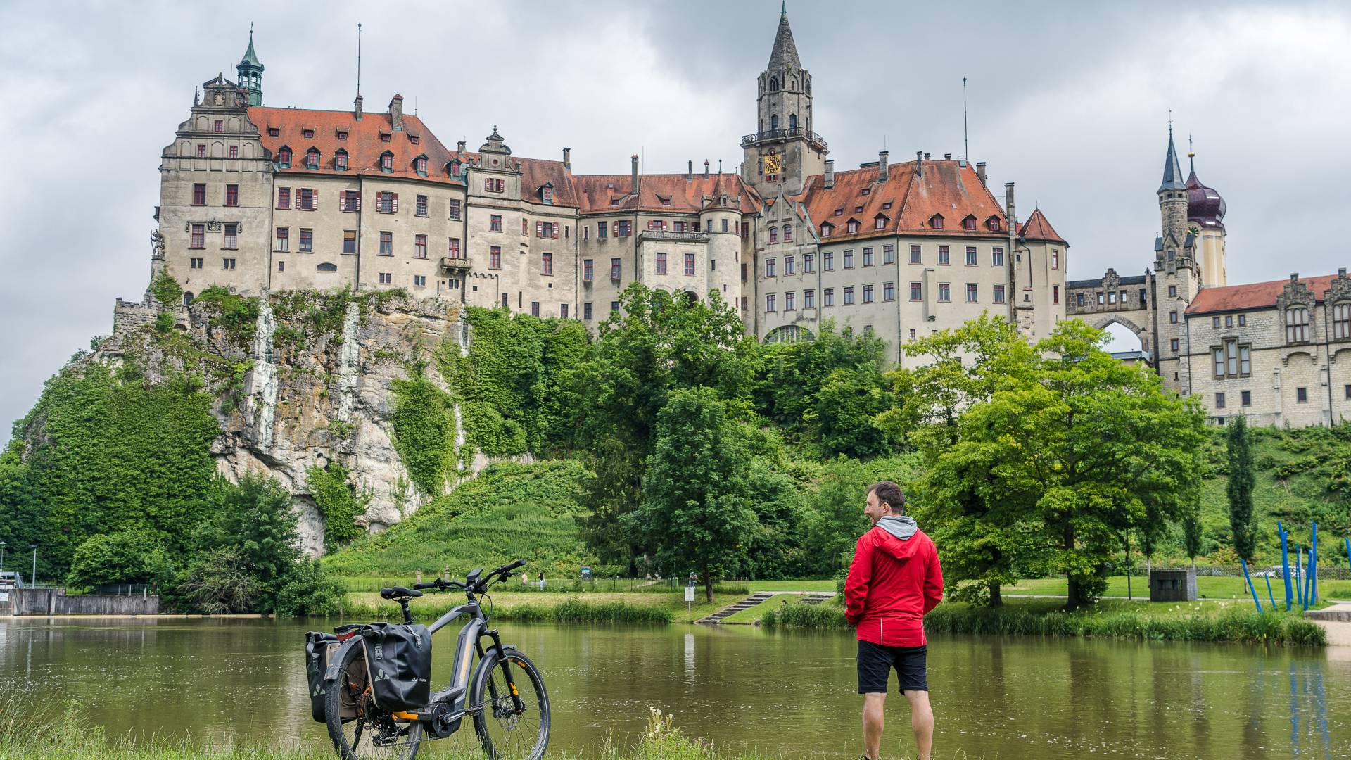 Radfahrer macht Pause vor Hohenzollern Schloss Sigmaringen